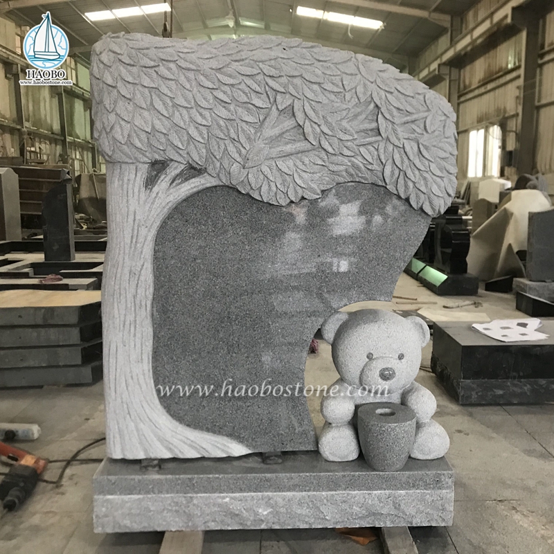 Geschnitzter Grabstein aus grauem Granit in Form eines Teddybären
